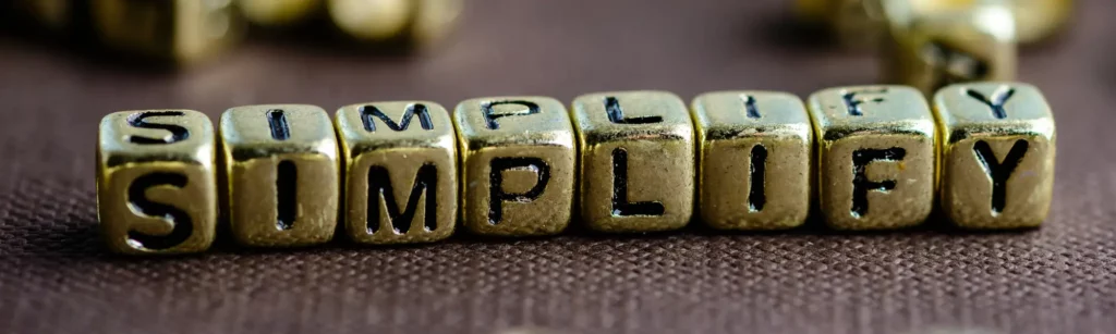 The word "simplified" carved into small wooden cubes. Because good leadership development can be found by simplifying the process!