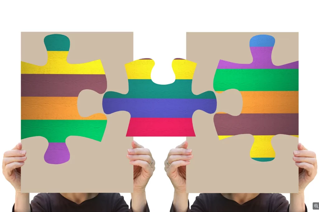 Two people connecting a puzzle with large jigsaw shapes